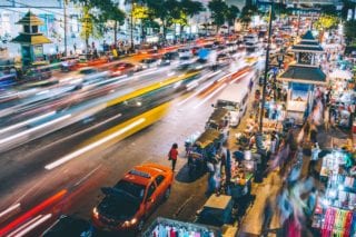 A blur of colorful cars speed down the highway in Thailand at dusk