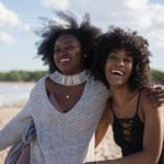 2 girls happily standing on the beach