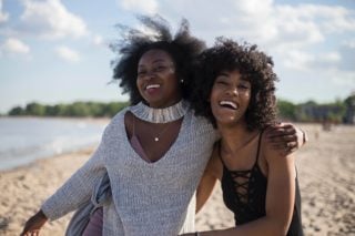 2 girls happily standing on the beach