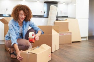 woman sealing box to ship