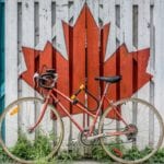 canadian flag painted on fence with bike in front