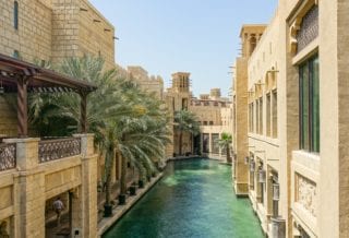 Aerial view of a pool in Dubai surrounding by a courtyard made of light bricks