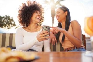 friends laughing at something on a cell phone 