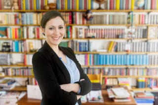 professor in Italy standing in front of books