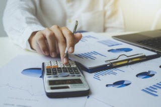 business person doing taxes with calculator