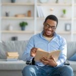 Black man in wheelchair reading book on other cultures