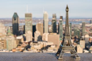 An Eiffel tower miniature against the Montreal skyline, symbolizing French expats