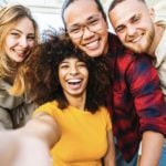 Four friends taking a selfie after making friends abroad