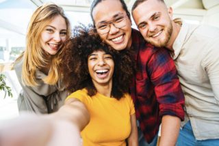 Four friends taking a selfie after making friends abroad