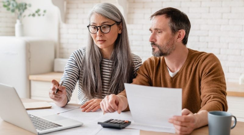 Middle-aged couple checking their budget for a move abroad