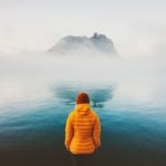 Expat dealing with depression standing at a cold lake