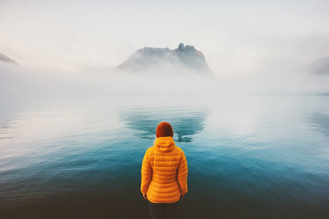 Expat dealing with depression standing at a cold lake