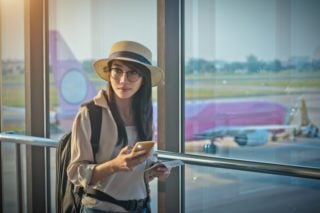 woman traveling on a digital nomad visa at the airport.