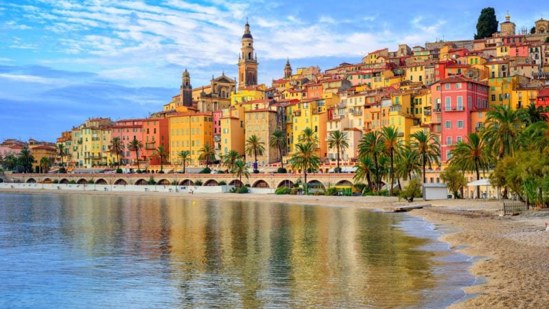 A photo of a beach and colorful buidlings in Nice, a famous city in France for expats.