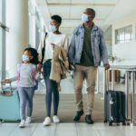 A family wearing masks while traveling in the time of COVID