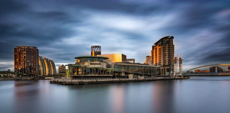A panoramic photograph of Media City At Salford Quays, Greater Manchester, UK. Featuring a stormy moody sky.
