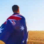 Man with a flag of Australia standing in field