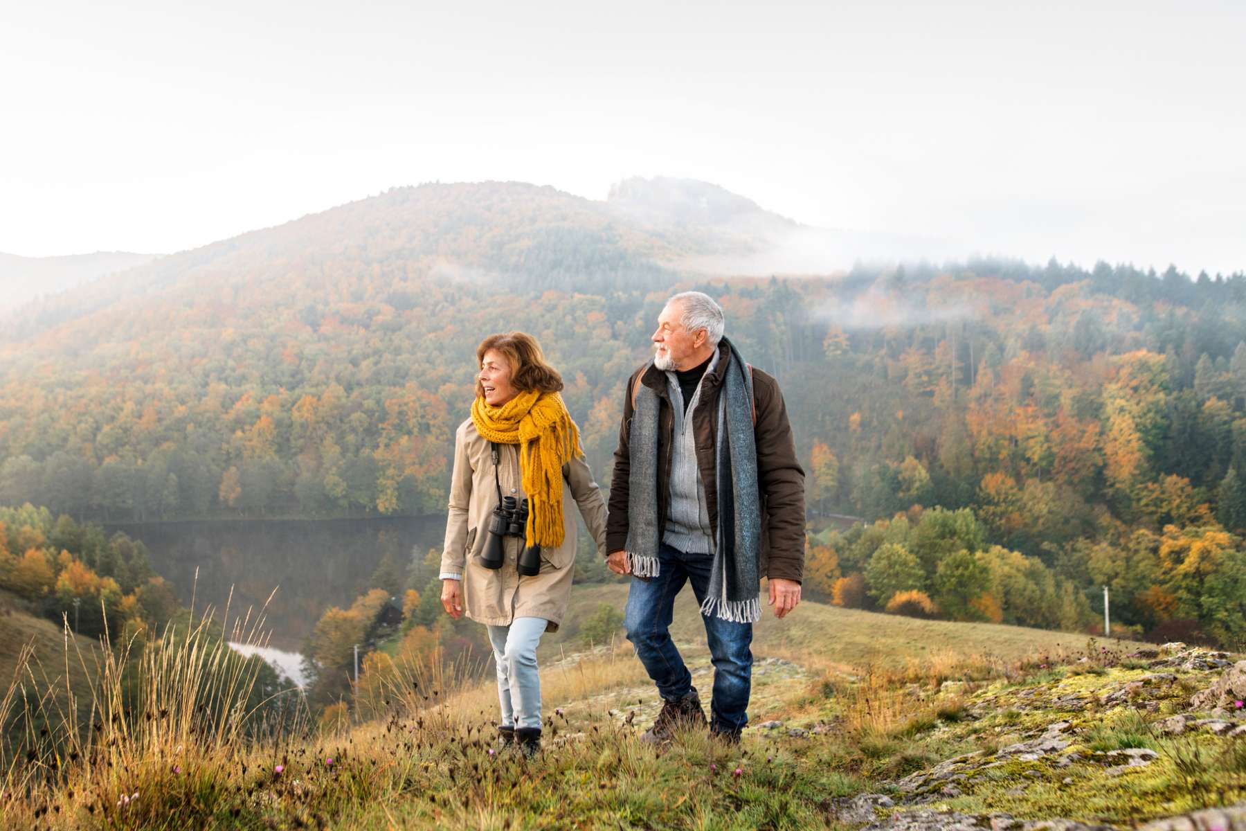 a retired expat couple holding hands and hiking among rolling hills in Slovakia