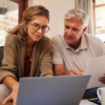 a couple sitting at a laptop research how to file their U.S. tax returns