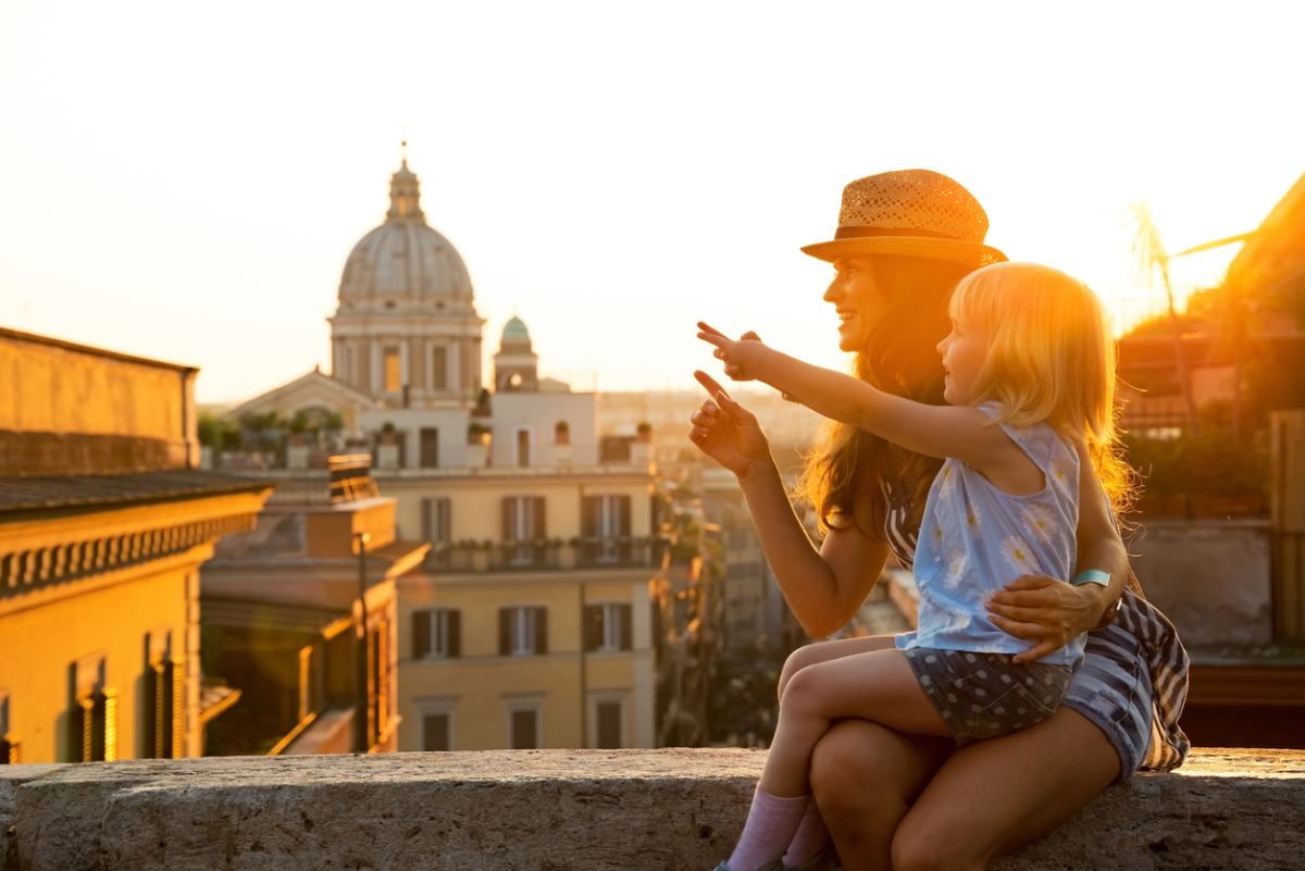 a mother and baby girl sitting on street in Rome, having moved there on an Italy work visa