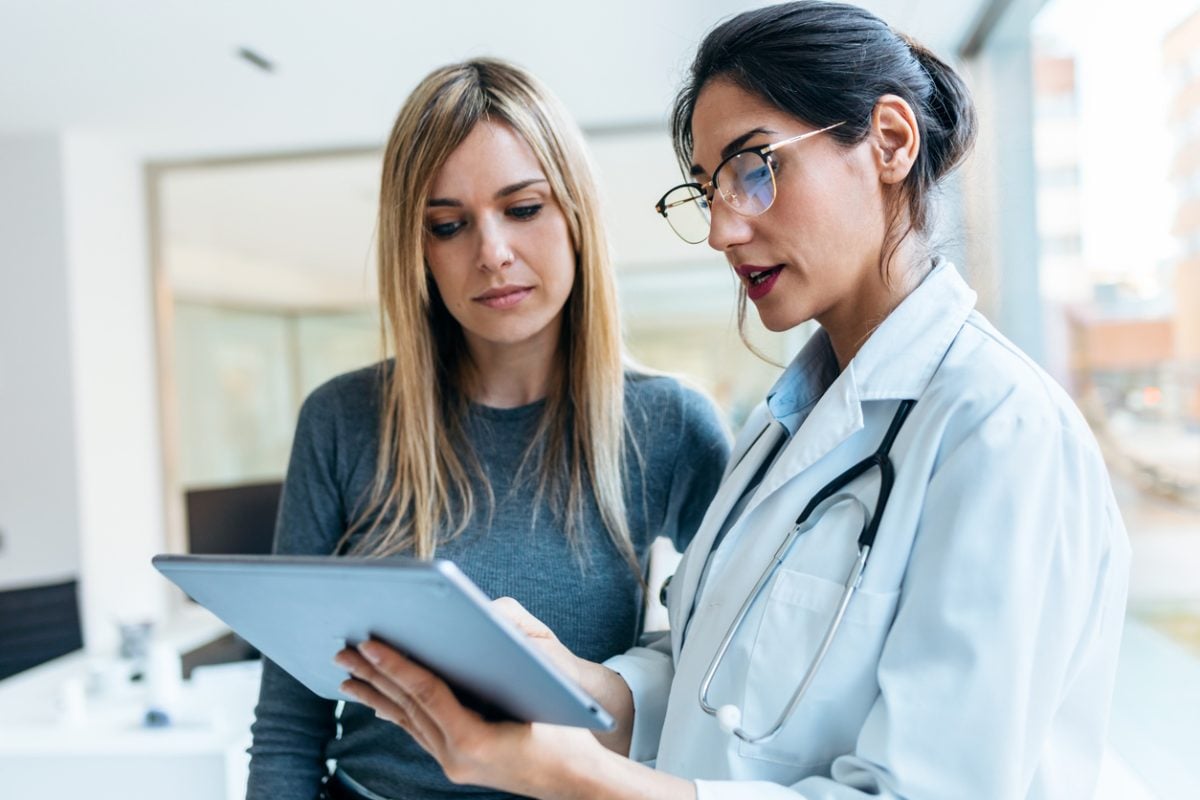 a female doctor explaining medical treatment with a patient who faces high medical bills as part of the high average cost of living in the U.S.