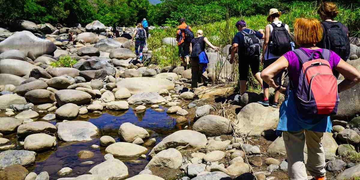 hiking-trail-boquete-panama a group of people hiking through the Rio Caldera river near the city of Boquete, Panama